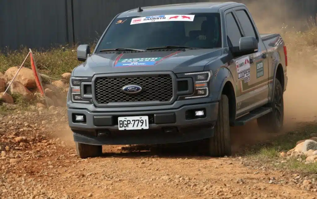 Gray Ford F-150 on a dirt track.