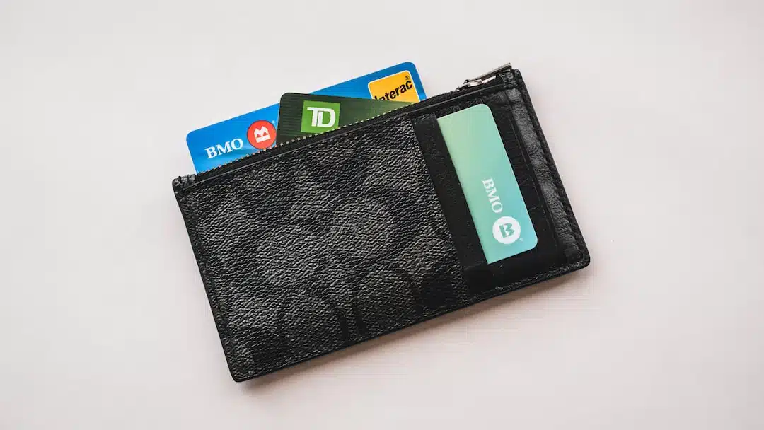 black wallet holding credit cards