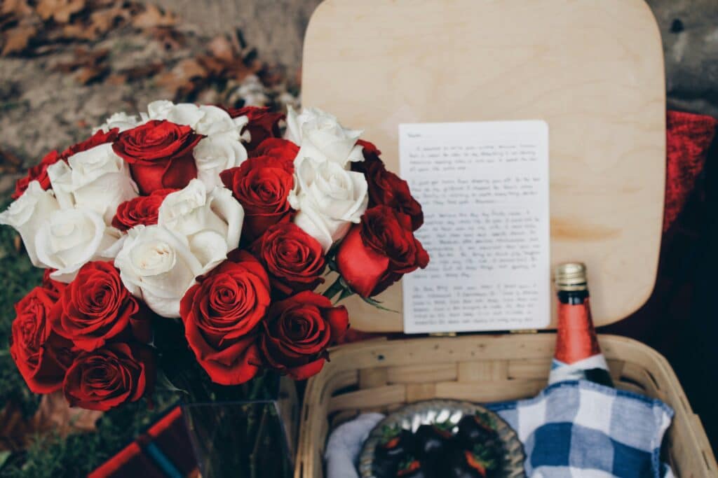 red and white roses, love letter notes, wine.