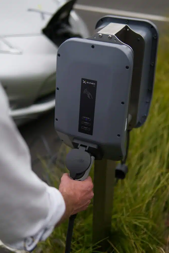 person holding a gray EV charger