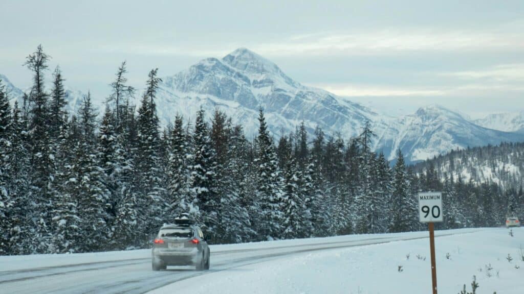 a white car on a snowy Canadian rockies background