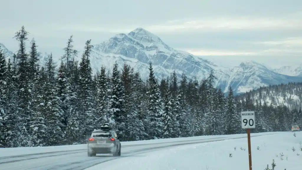 a white car on a snowy Canadian rockies background