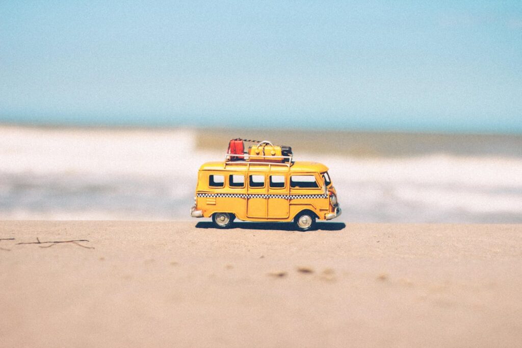miniature camper van right next to a beach