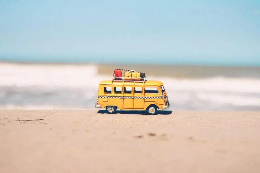 miniature camper van right next to a beach