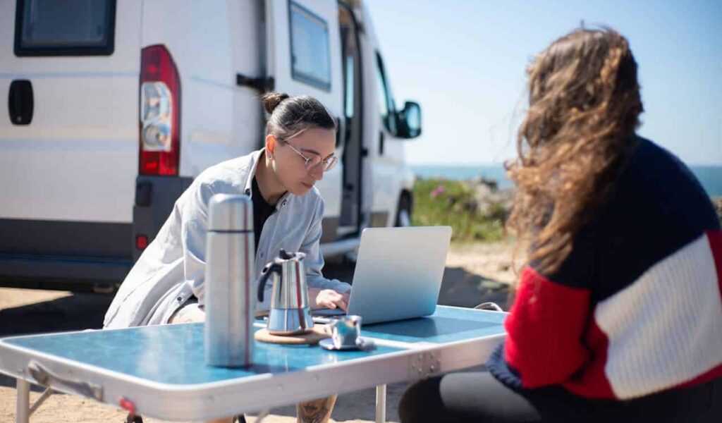 two women working on their laptop in the desert